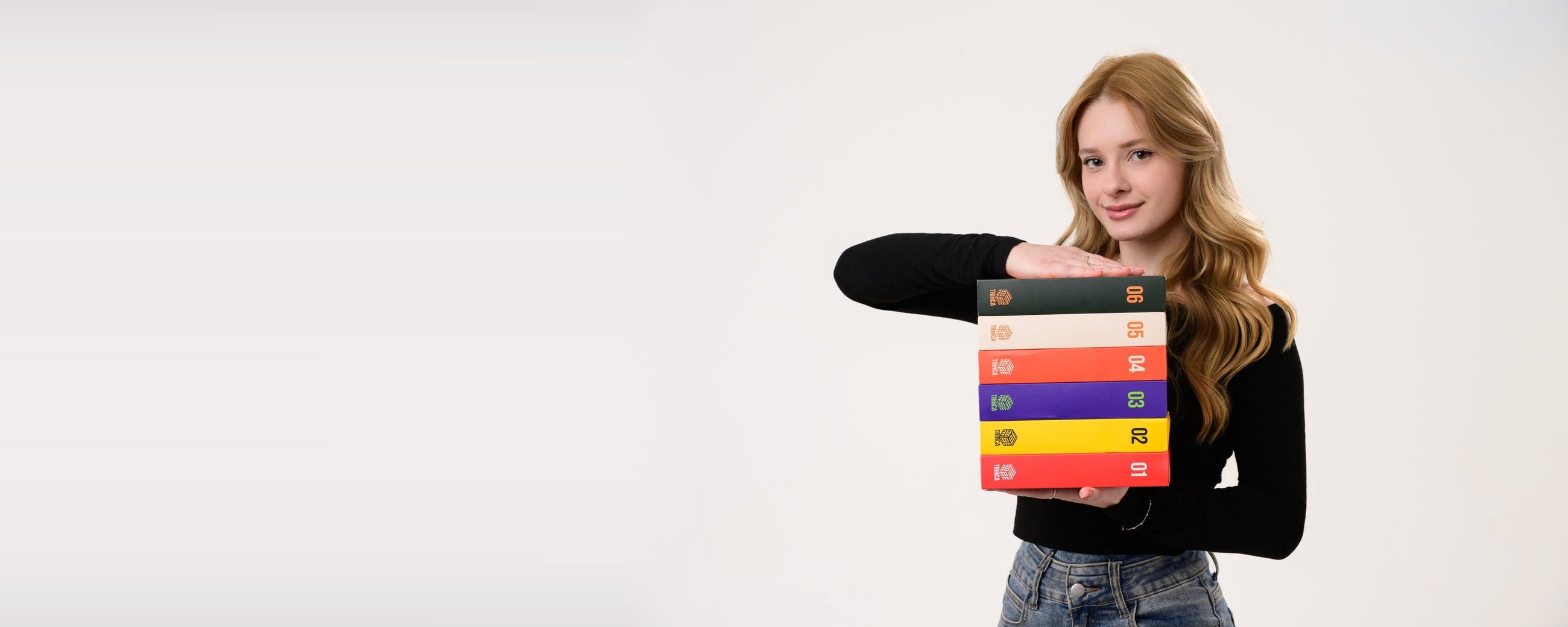 Julia segurando uma pilha de seis boxes da Trinca Literária